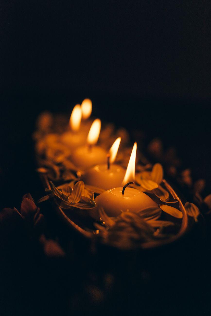 Floating candles among petals in low light